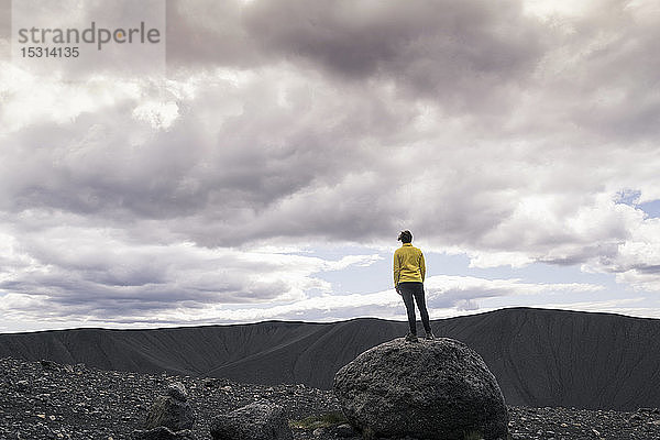 Junge Frau steht auf dem Krater Hverfjall in der Nähe von Myvatn  Island  und fotografiert