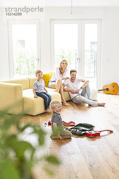 Glückliche Familie mit zwei Söhnen im Wohnzimmer ihres neuen Zuhauses