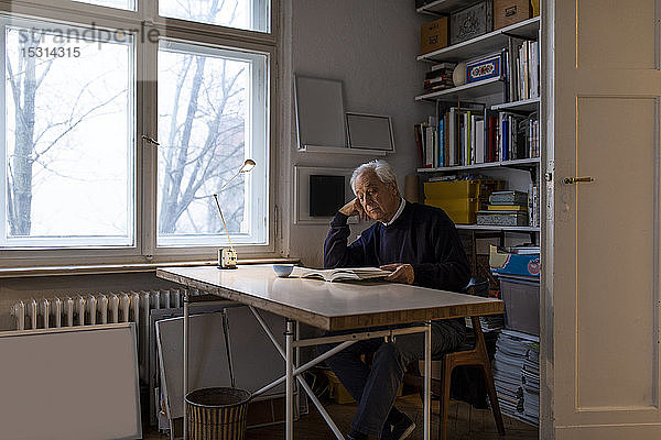 Älterer Mann liest zu Hause Buch