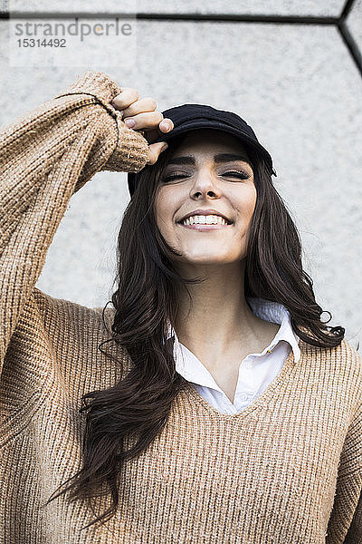 Porträt einer lächelnden jungen Frau mit Mütze