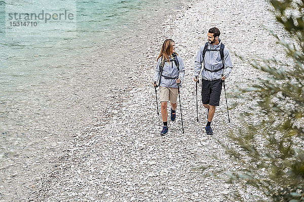 Junges Paar auf einer Wanderung zu Fuß am Flussufer  Vorderriss  Bayern  Deutschland