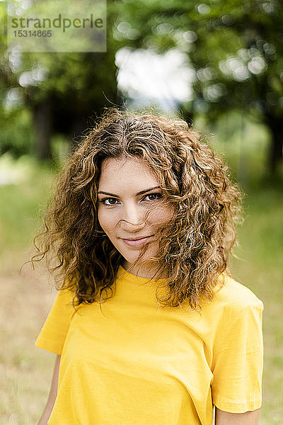 Porträt einer lächelnden jungen Frau in einem Park