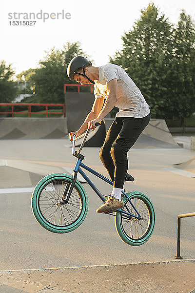 Junger Mann fährt BMX-Rad im Skatepark