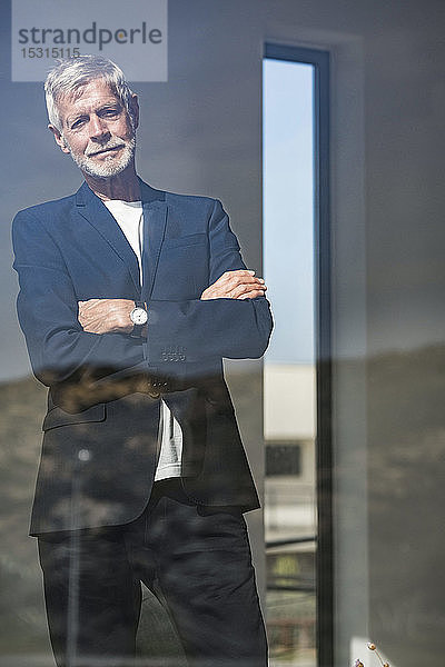 Porträt eines älteren Geschäftsmannes hinter einer Fensterscheibe