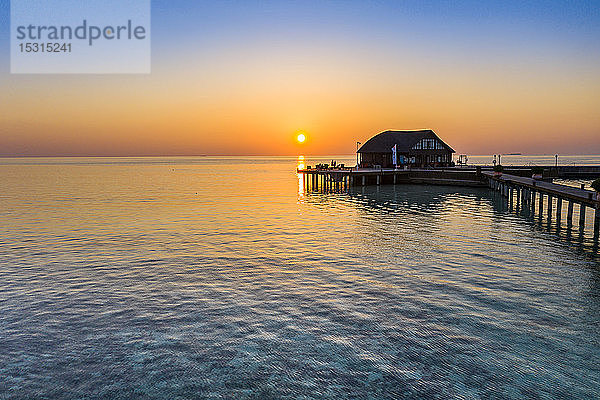 Malediven  Insel Olhuveli  Pier und Tauchschulgebäude auf der Lagune des Süd Male Atolls bei Sonnenuntergang