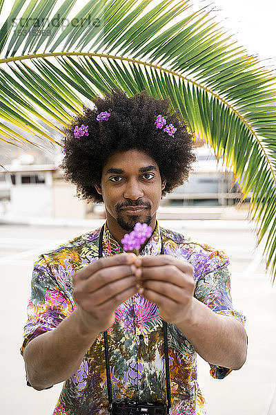 Bildnis eines Mannes mit Blüten im Haar und farbigem Hemd