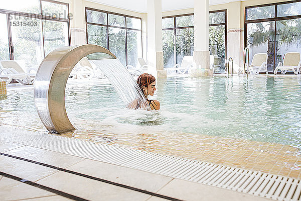 Junge Frau entspannt sich im Schwimmbad eines Spas