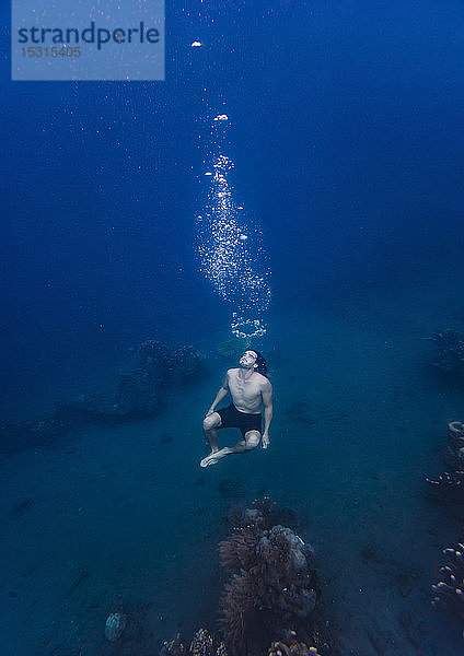 Junger Mann taucht unter Wasser