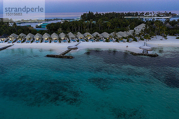 Malediven  Olhuveli-Insel  Resort und Piers auf der Lagune des Süd Male Atolls bei Sonnenuntergang