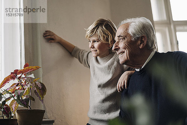 Großvater und Enkel zu Hause  die aus dem Fenster schauen