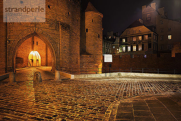 Kopfsteinpflasterstraße und Barbakantor zur Altstadt bei Nacht  Warschau  Polen