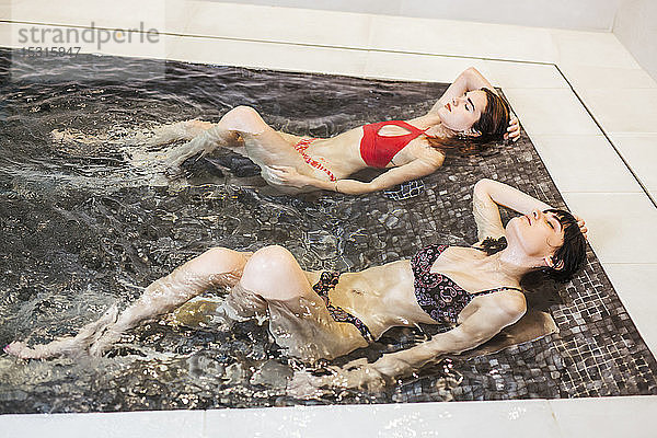 Zwei Frauen genießen den Whirlpool in einem Spa