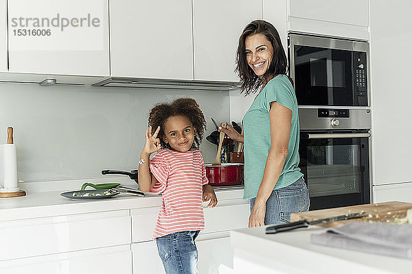 Glückliche Mutter und Tochter kochen gemeinsam in der Küche