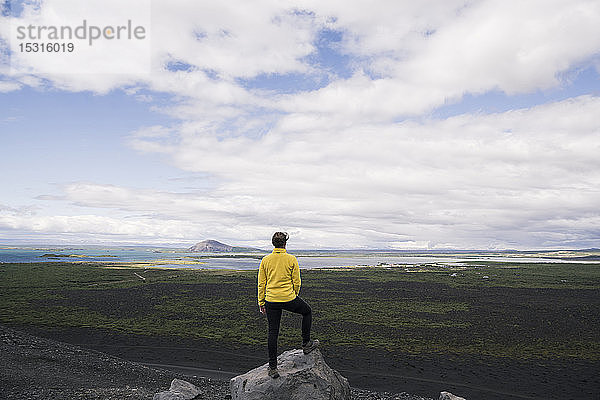 Junge Frau steht auf dem Hverfjall-Krater in der Nähe von Myvatn  Island  und schaut auf Aussicht