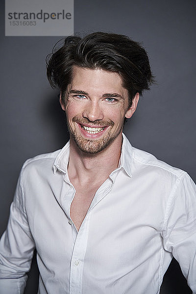Porträt eines lächelnden  gutaussehenden Mannes mit weißem Hemd