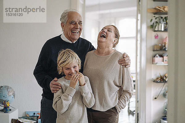 Lachende Großeltern mit Enkel zu Hause