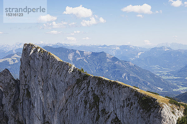 Wanderer auf dem Gipfel des Spinnerin vor blauem Himmel