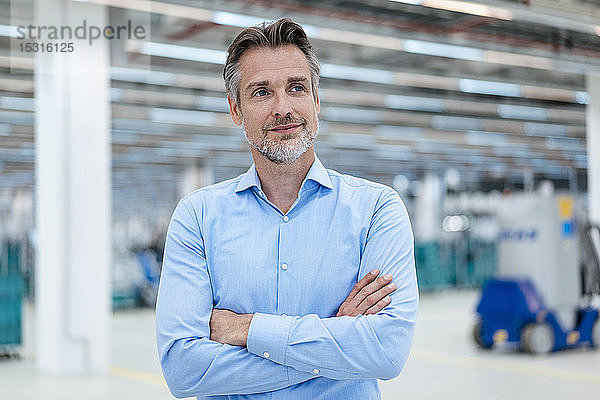 Porträt eines selbstbewussten Geschäftsmannes in einer Fabrikhalle