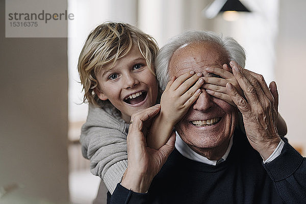 Glücklicher Enkel spielt mit Großvater zu Hause