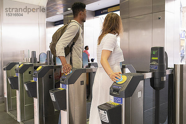 Junges Paar passiert U-Bahn-Gate mit elektronischen Tickets
