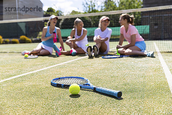 Reife Frauen im Tennisclub sitzen auf dem Platz und machen eine Spielpause