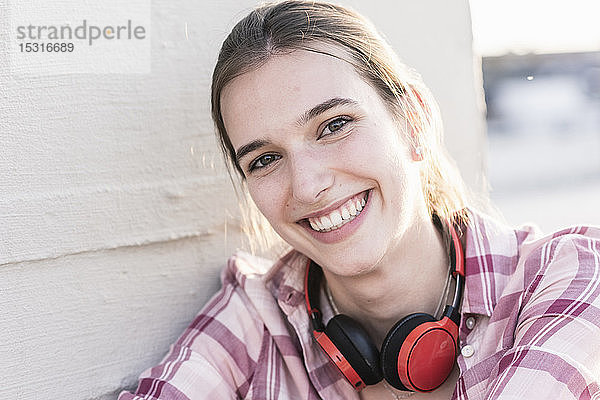 Porträt einer lächelnden jungen Frau mit Kopfhörer