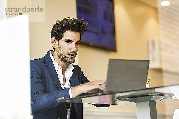 Fokussierter Geschäftsmann mit Laptop in einem städtischen Café