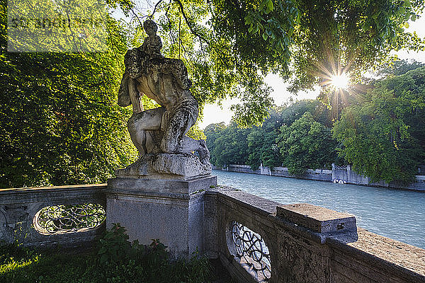 Deutschland  Oberbayern  München  Christophorus-Statue mit Bäumen umgeben von der Isar bei Sonnenuntergang