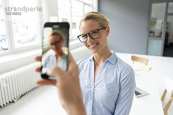 Smartphone-Bild einer jungen Geschäftsfrau im Amt