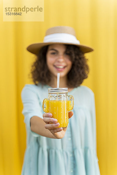 Bildnis einer Frau mit Strohhut  Saft trinkend  gelber Hintergrund