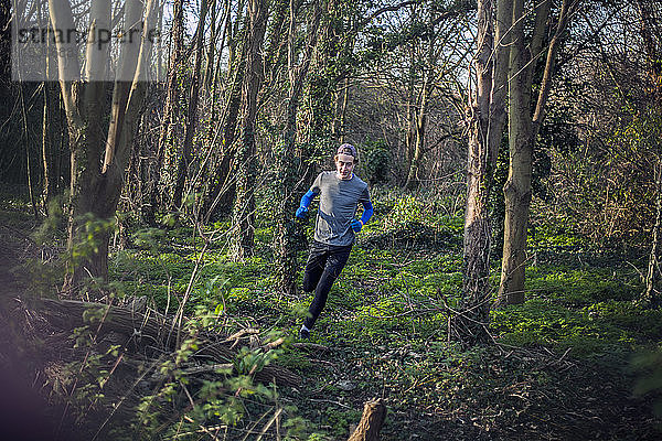 Junger Mann joggt durch den Wald