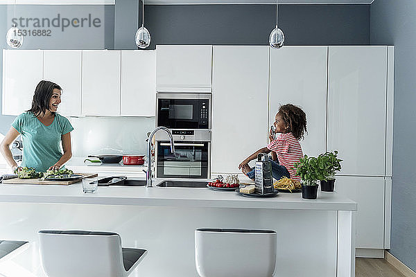 Glückliche Mutter und Tochter kochen gemeinsam in der Küche