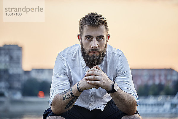 Bildnis eines im Freien sitzenden Mannes mit Bart und Tätowierung