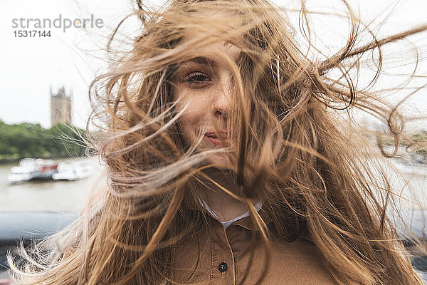 Porträt einer lächelnden jungen Frau mit windgepeitschtem Haar  London  UK