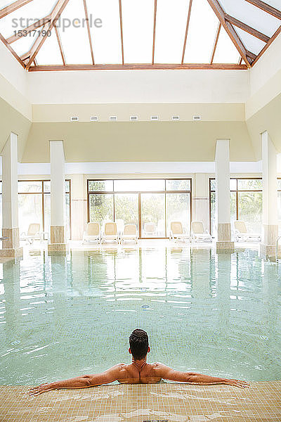 Mann entspannt sich im Schwimmbad eines Spas