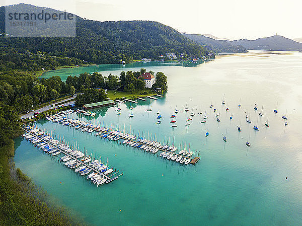 Luftaufnahme von Booten  die am Wörthersee am Anlegesteg im Hafen vor Anker liegen  gegen den Himmel bei Sonnenuntergang