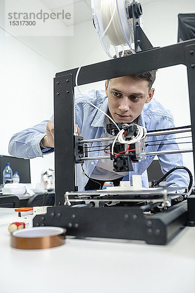 Schüler richten einen 3D-Drucker mit einem Laptop ein