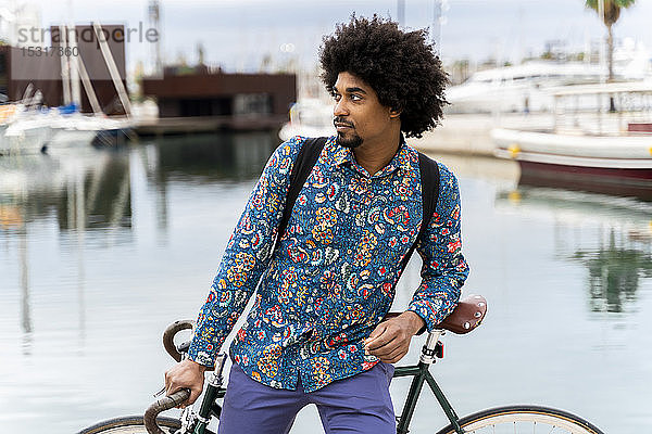 Stilvoller Mann mit Fahrrad am Yachthafen