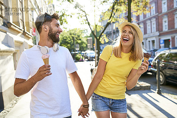 Glückliches junges Paar genießt Eiscreme in der Stadt