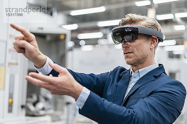 Geschäftsmann mit AR-Brille in einer modernen Fabrik