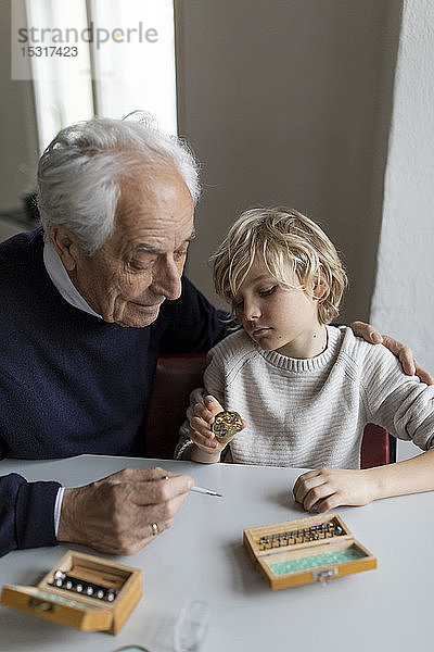 Uhrmacher und sein Enkel prüfen gemeinsam die Uhr