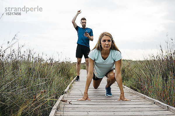 Joggerin mit ihrer Kutsche auf einem Holzlaufsteg