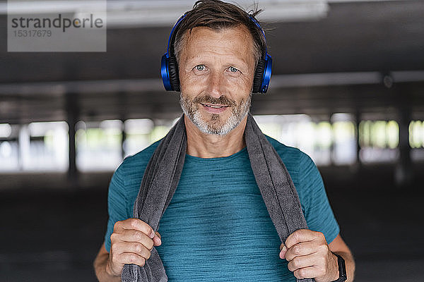 Porträt eines sportlichen Mannes mit Kopfhörern nach dem Training
