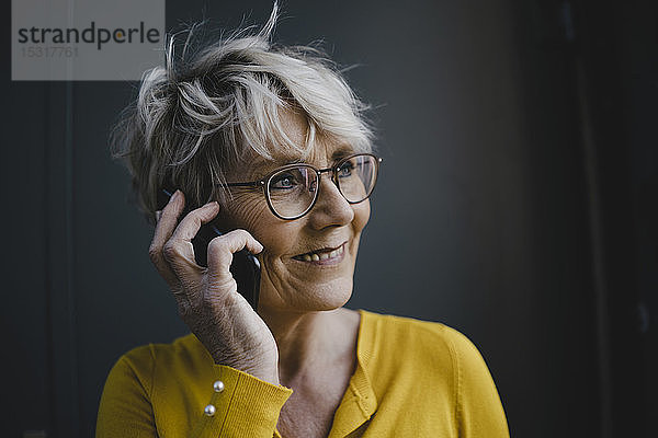 Porträt einer reifen Geschäftsfrau mit grauen Haaren am Telefon