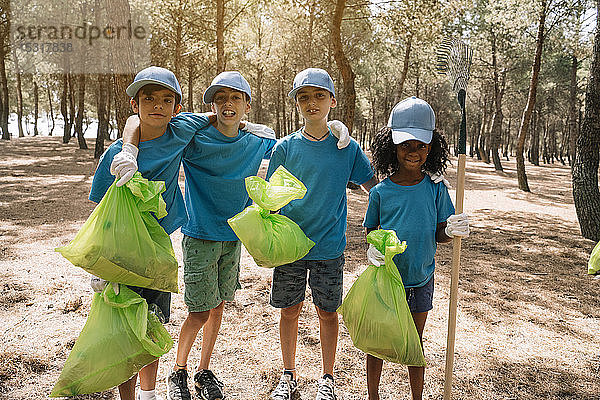 Gruppenbild von ehrenamtlich arbeitenden Kindern  die in einem Park Müll sammeln