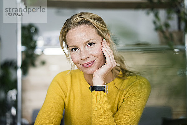 Porträt einer blonden Frau  die in einem Café sitzt