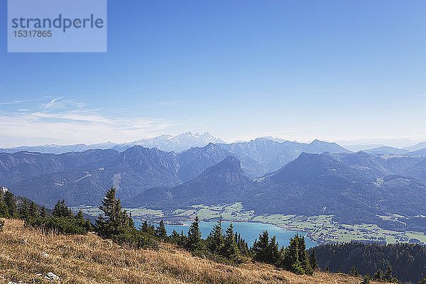 Idyllische Aufnahme von Bergen und Wolfgangsee vor blauem Himmel