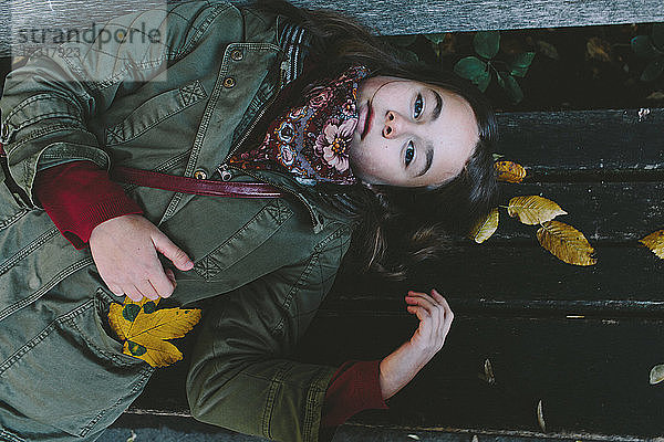 Porträt eines jungen Mädchens auf einer Parkbank liegend