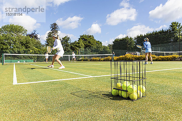 Ältere Frauen spielen Tennis auf Rasen