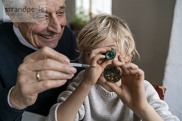 Uhrmacher und sein Enkel prüfen gemeinsam die Uhr